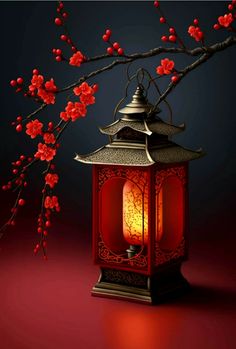 a red lantern sitting on top of a table next to a tree with red flowers