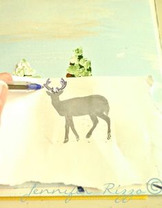 someone is drawing a deer on paper with a pencil