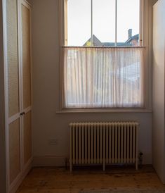 an empty room with a radiator and window