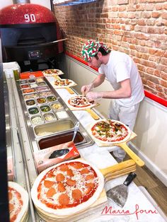 a man making pizzas at a restaurant