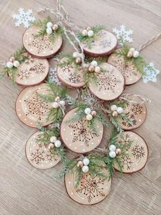 wooden ornaments with snowflakes and pine needles are arranged on a table in the shape of an ornament