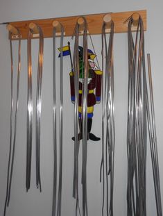 there are many skis hanging on the wall and in front of it is a man holding a flag