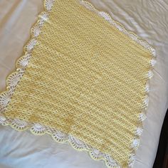 a yellow crocheted doily on a white bed