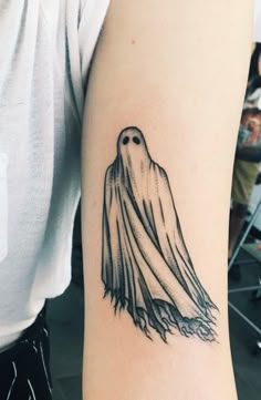 a black and white photo of a ghost tattoo on the arm