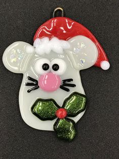 a glass ornament with a mouse wearing a santa hat