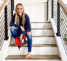 a woman is sitting on the stairs with a tool