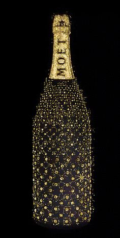 a bottle that has been decorated with gold and black flowers on it, in the dark