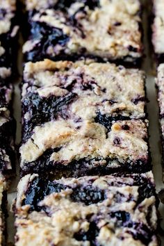 blueberry cheesecake bars cut into squares on a baking sheet