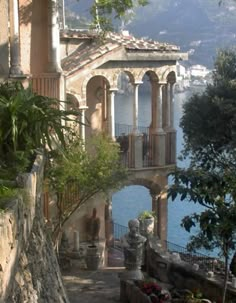 an old building with columns on the side and water in the backgrouds