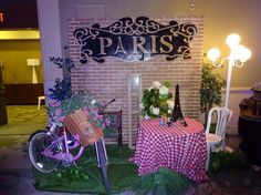 a table and chairs are set up in front of a brick wall with the word paris on it