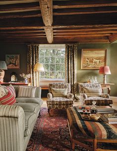 a living room with couches, chairs and rugs in front of a window