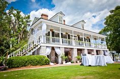 a large white house sitting on top of a lush green field