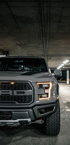 the front end of a truck parked in a parking garage with no one around it