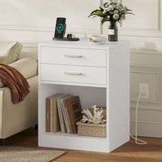 a white table with a phone and some books on it next to a couch in a living room