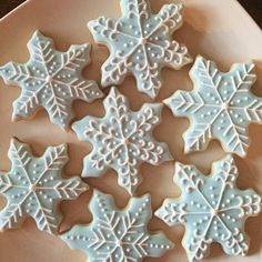 snowflake cookies are arranged on a plate