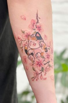 a cat with flowers on its arm and behind it is an apple blossom tattoo design