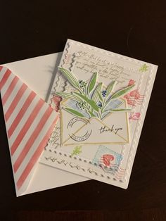 two envelopes with designs on them sitting next to each other, one has a flower in it