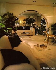 a living room filled with furniture and plants