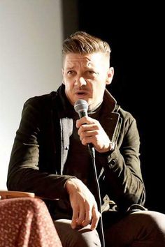 a man holding a microphone while sitting down