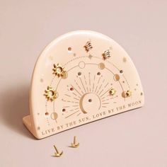 the sun and moon clock is on display with tiny gold studs around it's edges