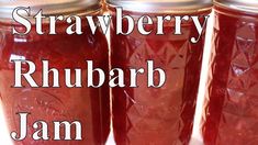 three jars filled with red liquid sitting on top of a white table next to the words strawberry rhubarb jam