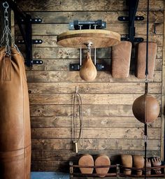 a wooden wall with boxing gloves hanging from it's hooks and punching mitts