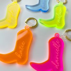 four different colored plastic keychains with the names of each person on one side