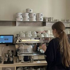 a woman standing in front of a coffee machine