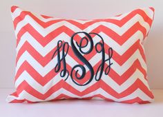 a red and white chevroned pillow with the letter s in black on it