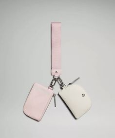 two pink and white luggage tags attached to each other on a gray background with silver hardware