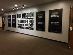 three black and white posters are on the wall in an empty room with carpeted flooring