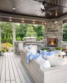 an outdoor living area with couches and fireplace