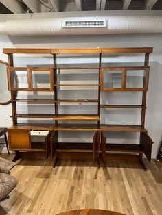 a living room filled with furniture on top of a hard wood floor covered in lots of shelves