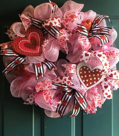 a pink wreath with hearts on the front door