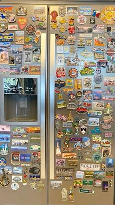 a stainless steel refrigerator covered in magnets and stickers