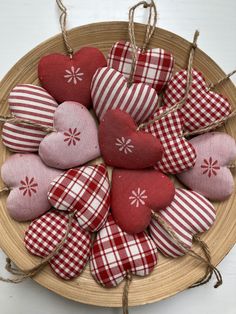 several red and white heart shaped cushions in a woven basket with twine string on top