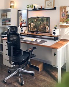 a desk with a chair, computer monitor and other items on top of the desk