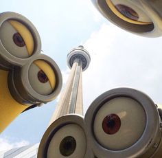 looking up at the top of two tall buildings with speakers attached to it's sides