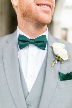 a close up of a man wearing a suit with a flower in his lapel