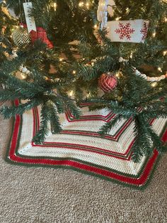 the christmas tree is decorated with red, white and green striped crocheted afghans