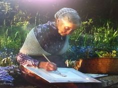 an older woman is writing in her garden