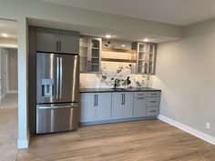 an empty kitchen with stainless steel appliances and wood flooring is pictured in this image