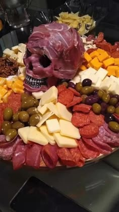 a platter filled with meats, cheeses and olives