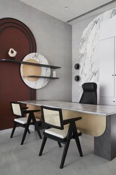 a room with two chairs and a marble table in the center, along with a round mirror on the wall