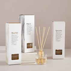 three boxes and two reed diffusers on a table