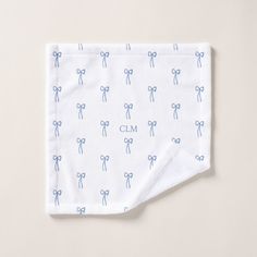 a white cloth with blue bows and the word clm on it is folded in half