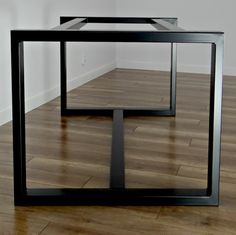 two tables sitting on top of a hard wood floor next to each other in front of a white wall