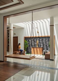 a woman sitting on a swing in the middle of a room