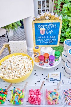 a table topped with lots of food next to a cupcake and ice cream cone