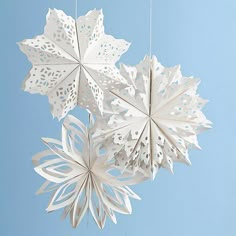 three white paper snowflakes hanging from strings